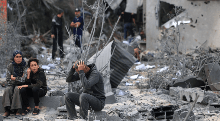 عائلة فلسطينية تجلس على ركام منزلها المدمر في غزة