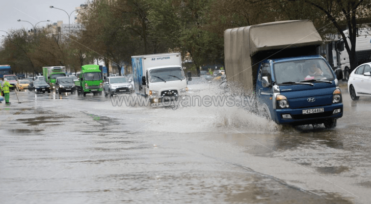 مركبات تسير في أحد شوارع العاصمة عمان بعد هطول الأمطار