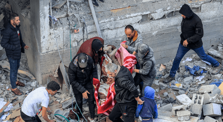 فلسطينيون ينتشلون شهداء في أعقاب غارة للاحتلال على مخيم المغازي - AFP