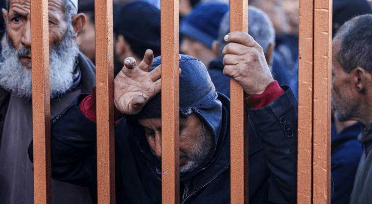 فلسطينيون يقفون عند مدخل مشرحة مركز ناصر الطبي في قطاع غزة للتعرف على جثامين أقارب لهم