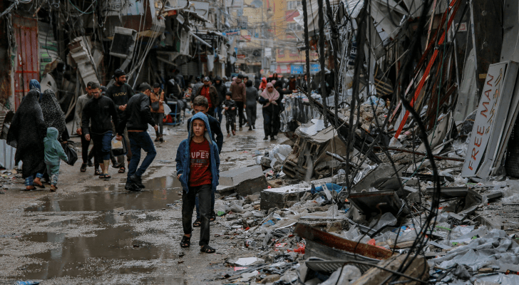 فلسطينيون يسيرون وسط الدمار في قطاع غزة