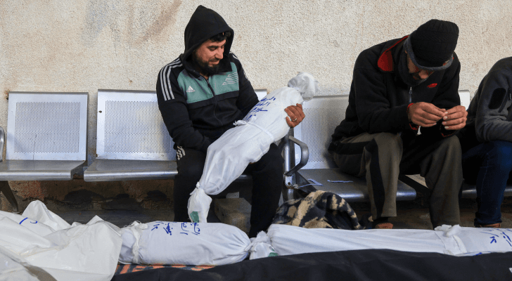 فلسطيني يحمل طفل استشهد جراء عدوان الاحتلال على غزة