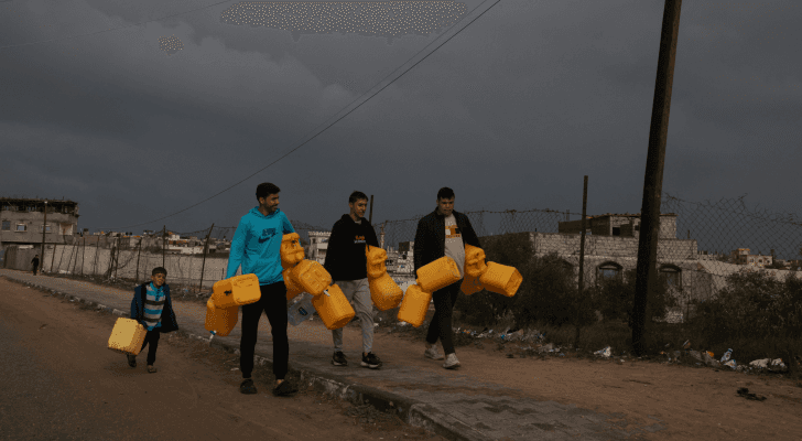 نازحون فلسطينيون يحملون غالونات في طريقهم للحصول على المياه في رفح جنوبي قطاع غزة