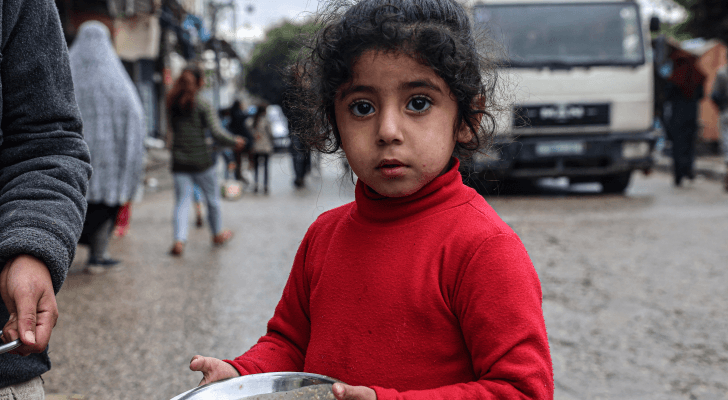 طفلة في غزة تحمل الطعام الذي حصلت عليه من المساعدات