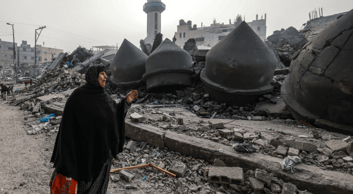 مسنة فلسطينية تسير بالقرب من مسجد الفاروق الذي دمره قصف الاحتلال في رفح - AFP
