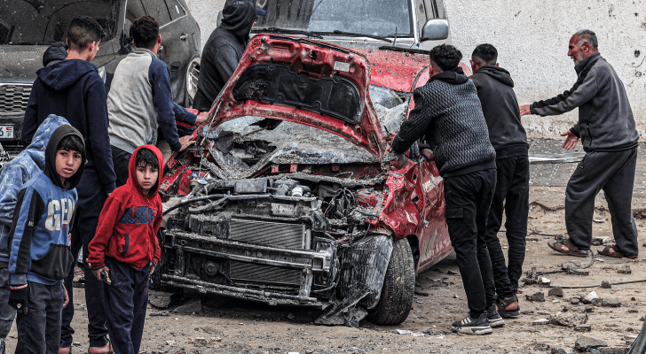 رجال وشباب يتجمعون لتفقد مركبة مدمرة في أعقاب قصف الاحتلال لرفح