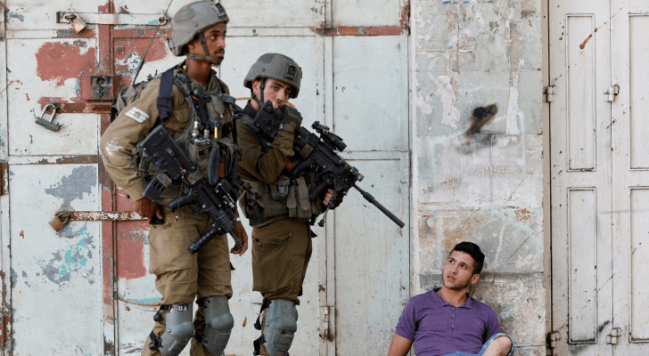 عناصر من قوات الاحتلال يرفعون سلاحهم صوب فلسطيني - أرشيفية