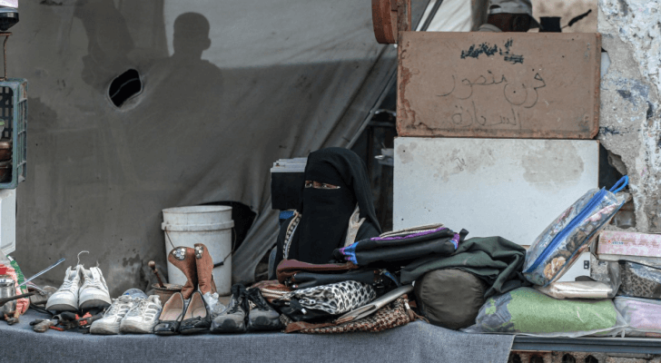 امرأة فلسطينية تبيع أحذية وأشياء أخرى في دير البلح وسط قطاع غزة