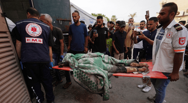 مسعفون يحملون أحد الشهداء  في دير البلح