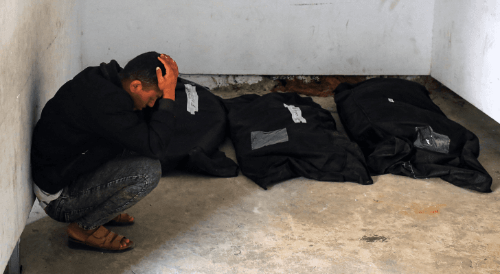 شاب فلسطيني يجلس بجانب جثامين الشهداء في رفح جنوب قطاع غزة