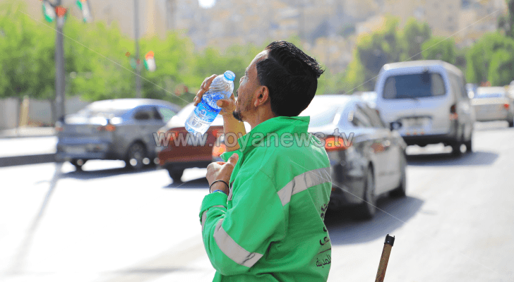عامل وطن يشرب الماء وسط الأجواء الحارة في العاصمة عمان