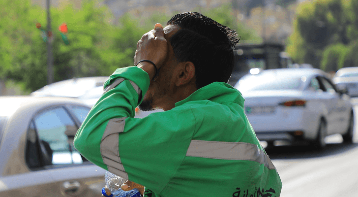 عامل وطن في العاصمة عمان يعمل تحت أشعة الشمس