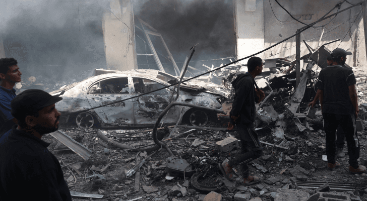 فلسطينيون وسط دمار خلفه قصف الاحتلال في مخيم النصيرات بوسط قطاع غزة