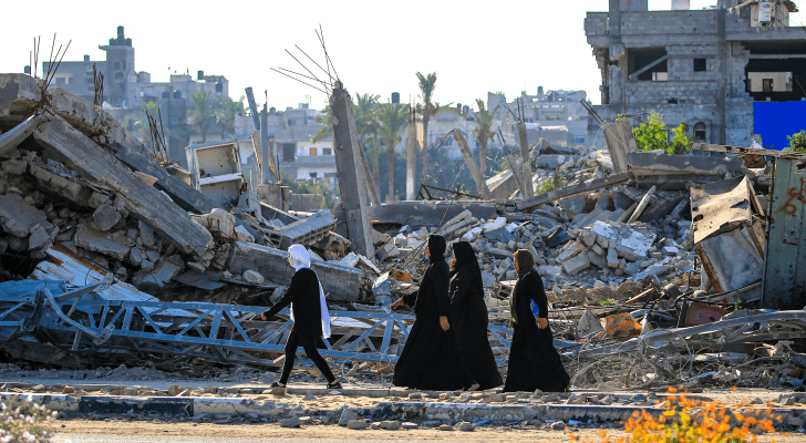 سيدات فلسطينيات بجانب المباني المدمرة جراء قصف مخيم البريج وسط غزة