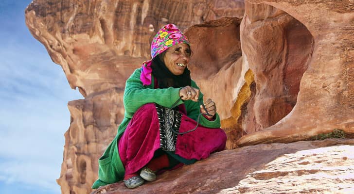 أردنية ترتدي الزي التراثي الأردني وتجلس في منطقة أثرية