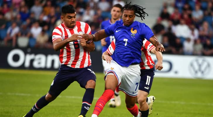 اللاعب مايكل أوليز (يمينا) يركض بالكرة خلال مباراة