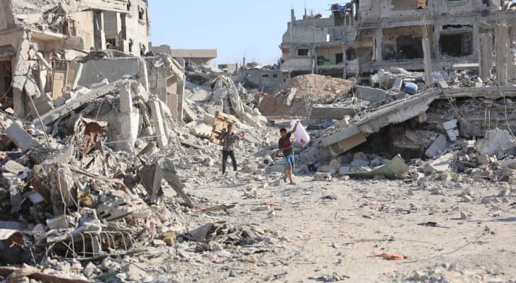 فلسطينيون وسط أنقاض المباني المدمرة بعد انسحاب جيش الاحتلال من حي الشجاعية