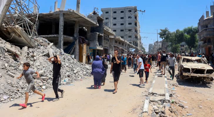 فلسطينيون وسط الدمار الذي خلفه قصف الاحتلال في مخيم البريج للاجئين في وسط قطاع غزة