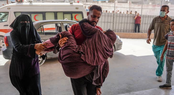 فلسطيني يسعف سيدة إلى مستشفى ناصر في أعقاب استهداف الاحتلال خان يونس