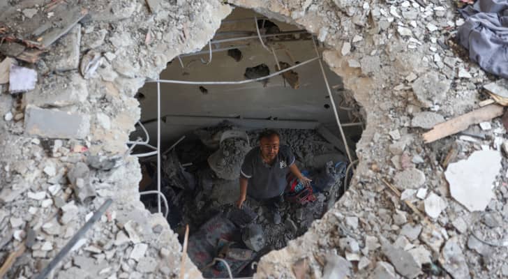 فلسطيني يتفقد الأضرار الناجمة عن غارة للاحتلال على مدرسة خديجة التي تؤوي النازحين في دير البلح