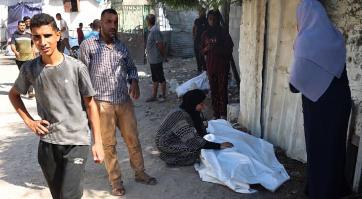 فلسطينيون بالقرب من جثمان أحد الشهداء في مخيم البريج وسط قطاع غزة
