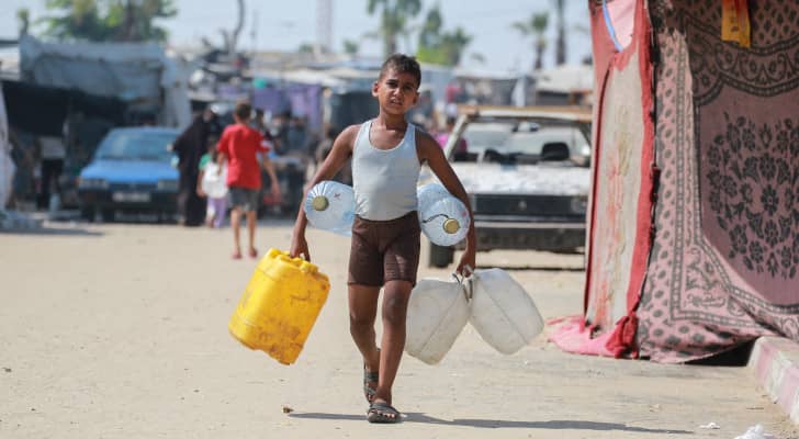 فتى فلسطيني يحمل عبوات مياه  في خان يونس بجنوب قطاع غزة