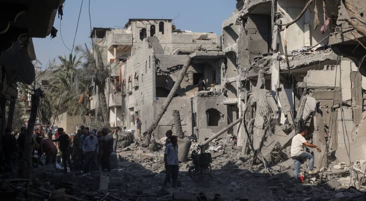 فلسطينيون يتفقدون الدمار في دير البلح بوسط قطاع غزة بعد قصف الاحتلال