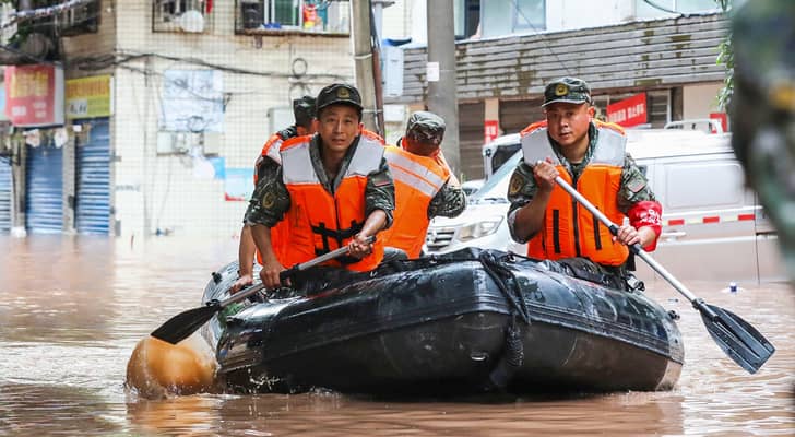رجال الشرطة شبه العسكرية يبحثون في منطقة غمرتها مياه الأمطار الغزيرة في تشونغتشينغ بجنوب غرب الصين في 4 يوليو
