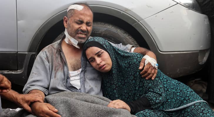 فلسطيني يختضن ابنته بعد إصابته بجروح نتيجة لعدوان الاحتلال على القطاع غزة