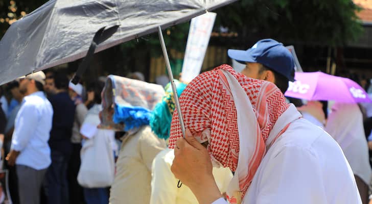 شخص يحمل مظلة للوقاية من أشعة الشمس