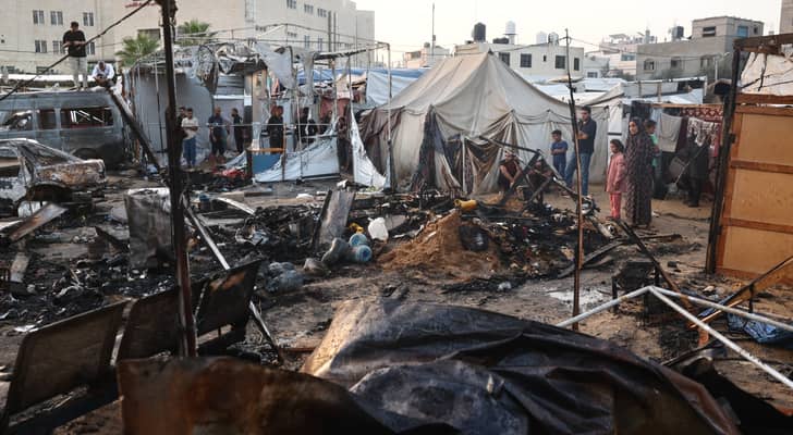 فلسطينيون يتحققون من الدمار الذي أعقب غارة لللاحتلال حول خيام النازحين داخل أسوار مستشفى شهداء الأقصى في دير البلح