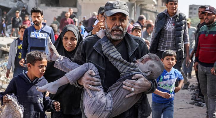 فلسطيني يحمل ابنه لمحاولة إنقاذه في قطاع غزة "أ ف ب"
