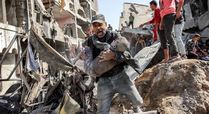 فلسطيني يحاول إنقاذ ابنه من الاستهدافات