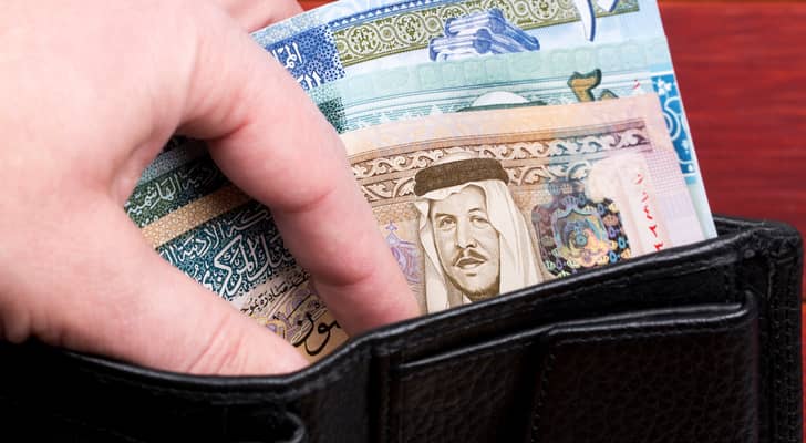 شخص يحمل محفظة بداخلاها مبلغ مالي