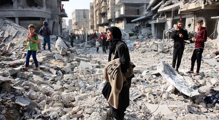 فلسطينيون يسيرون وسط الدمار بعد غارة للاحتلال على جباليا في شمال قطاع غزة