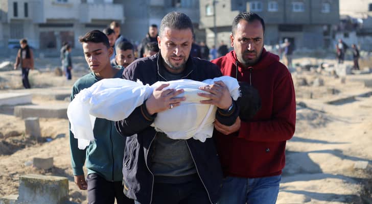 فلسطينية يحمل طفله الشهيد في قطاع غزة "أ ف ب"