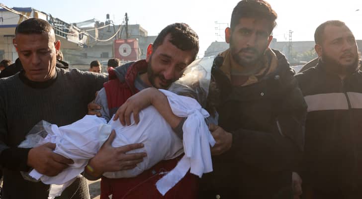فلسطيني يحمل جثمان نجله الشهيد في غزة