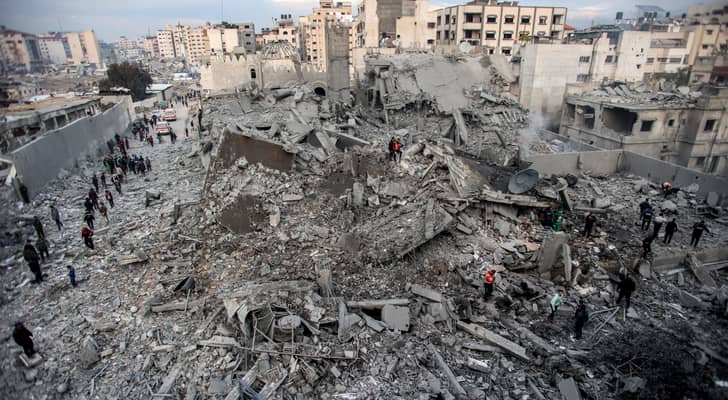 فلسطينيون بين أنقاض مبنى سكني منهار نتيجة قصف الاحتلال حي الرمال وسط غزة