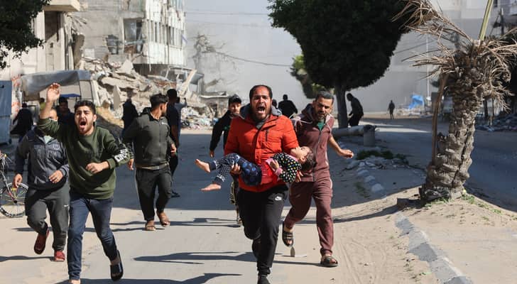 فلسطينيون يهرعون بفتاة مصابة بعيدا عن موقع غارات الاحتلال على مخيم نازحين مؤقت وسط مدينة غزة
