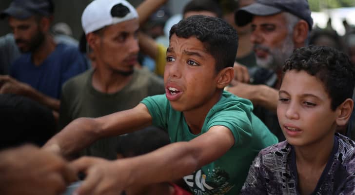 أطفال فلسطينيون يطلبون الغذاء في مخيم النصيرات للاجئين في وسط قطاع غزة