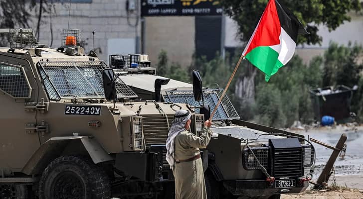 مسن فلسطيني يرفع علم بلاده أمام آليات  الاحتلال في الضفة الغربية