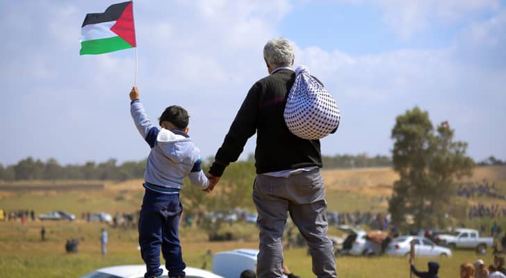 فلسطيني ونجله يرفع علم فلسطين