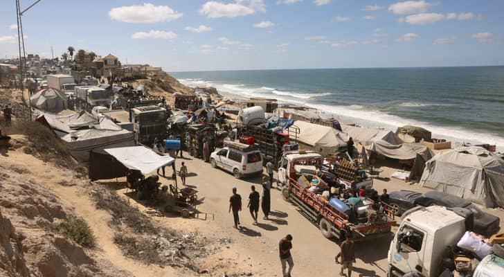فلسطينيون يحملون متاعهم يسيرون على طريق ساحلي شمال غربي مخيم النصيرات بعد نزوحهم جنوبا