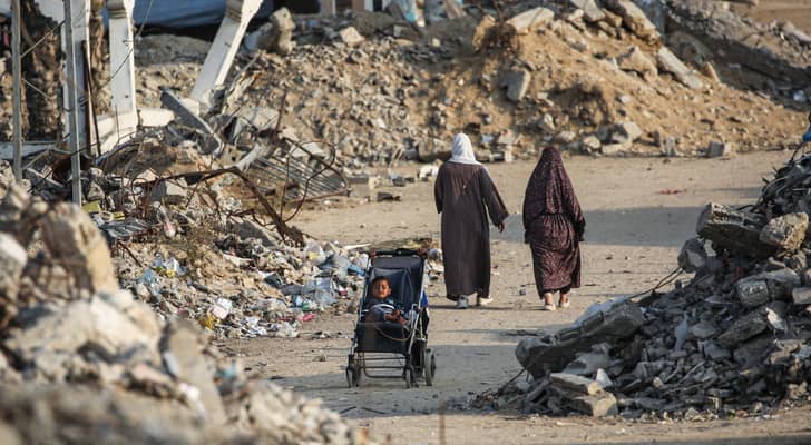 سيدات فلسطينيات يتجولن في احدى مناطق غزة المدمرة