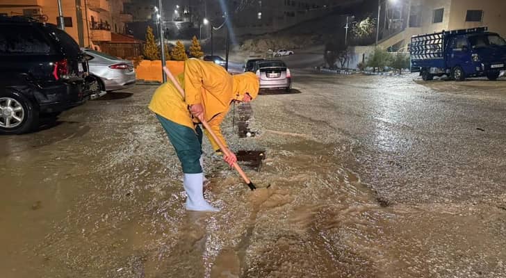 أحد كوادر البلديات يتعامل مع فيضان منهل مياه