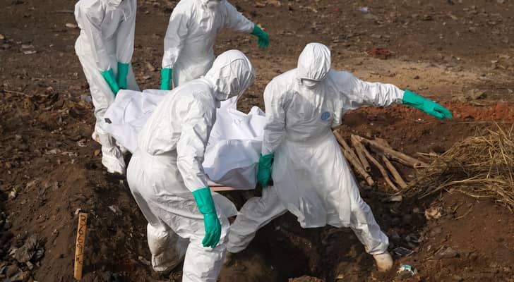 العاملون الصحيون يحملون جثة شخص يشتبه بإصابته بفيروس إيبولا
