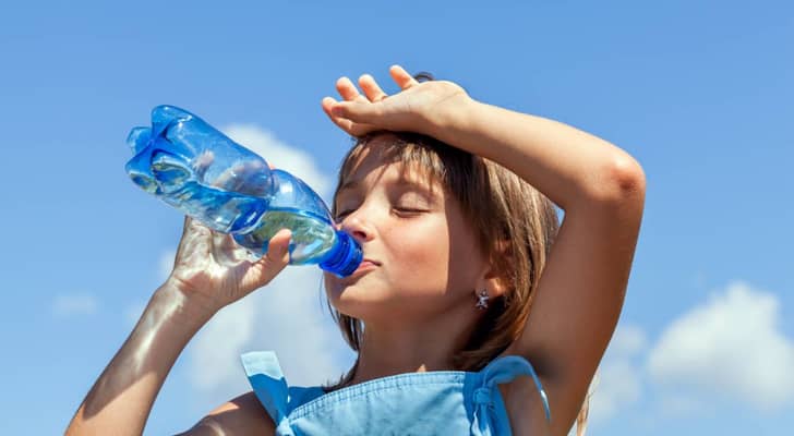 طفلة تشرب المياه بسبب ارتفاع درجات الحرارة