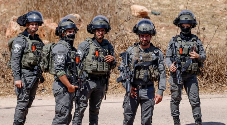 جنود "إسرائيليون" يقفون حراسا أثناء هدم مبنى فلسطيني